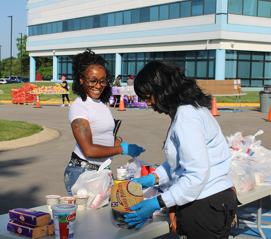 Two women volunteering for harvesters